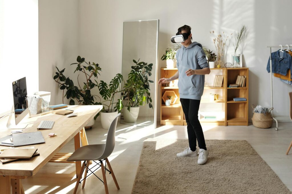 Person wearing a VR headset in a bright living room with plants and furniture.